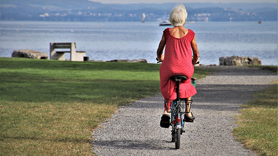 Ältere Radfahrerin am Ufer des Bodensees