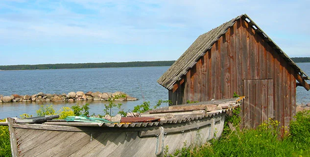 Rustikale, mit Holz verkleidete Hütte und ein altes Holzboot, traditionelle Fischerkultur