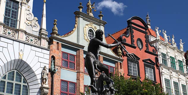 Auf einer Radreise vorbei an Statue und altes Häuserwerk in Danzig