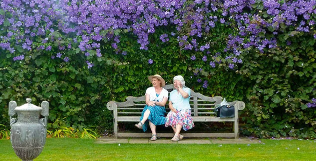 Zwei Frauen auf einer Parkbank im Grünen in Südengland, fotografiert auf einer Radreise