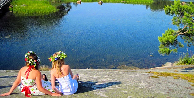 Zwei Frauen sitzen vor einem See
