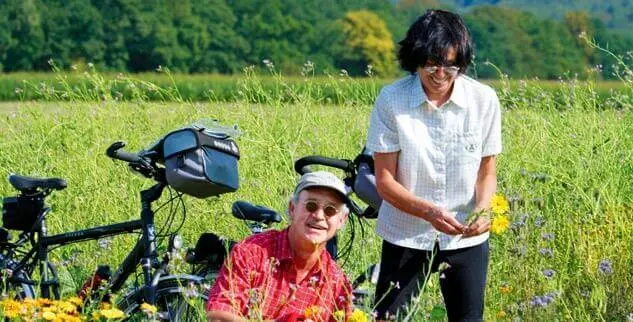 Glückliche Radfahrer im Blumenbeet