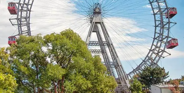 Auf dem Bild sind ein Riesenrad und einige Bäume zu sehen