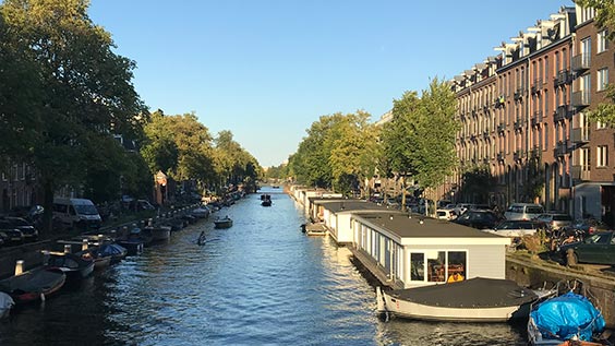Radwege entlang der berühmten Grachten in Amsterdam, Niederlande, gesäumt von traditionellen Gebäude