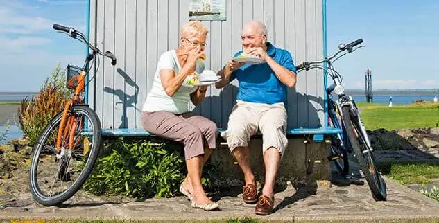 Radfahrer der Landpartie machen eine Pause in Nordfriesland und essen Fischbrötchen